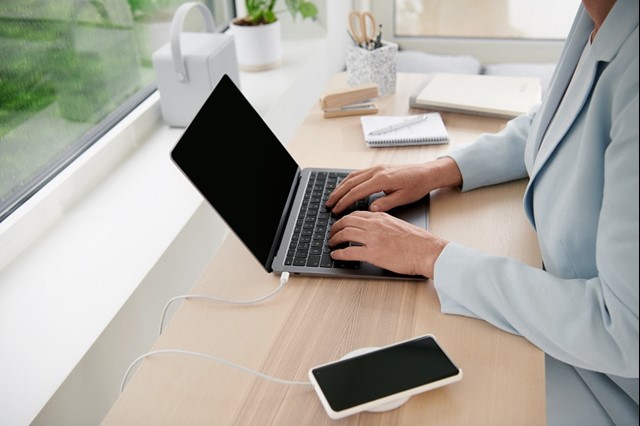 Vrouw met smartphone en laptop op een bureau | Klokkenluidersregeling Vattenfall