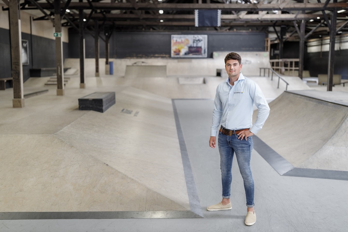 Vlotte adviseur in nette spijkerbroek in indoor skatepark