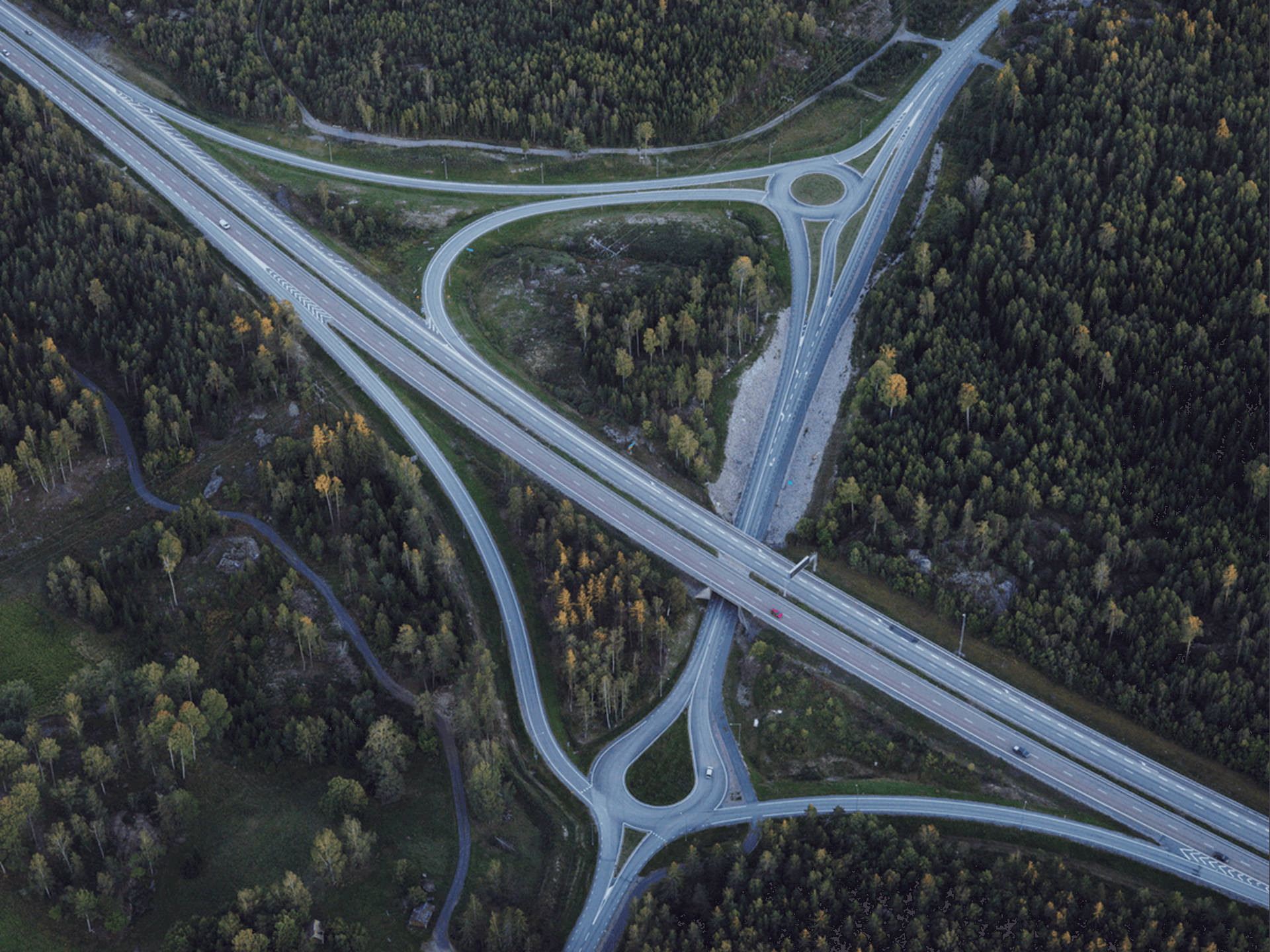 Luchtfoto van samenkomende wegen tussen de bomen