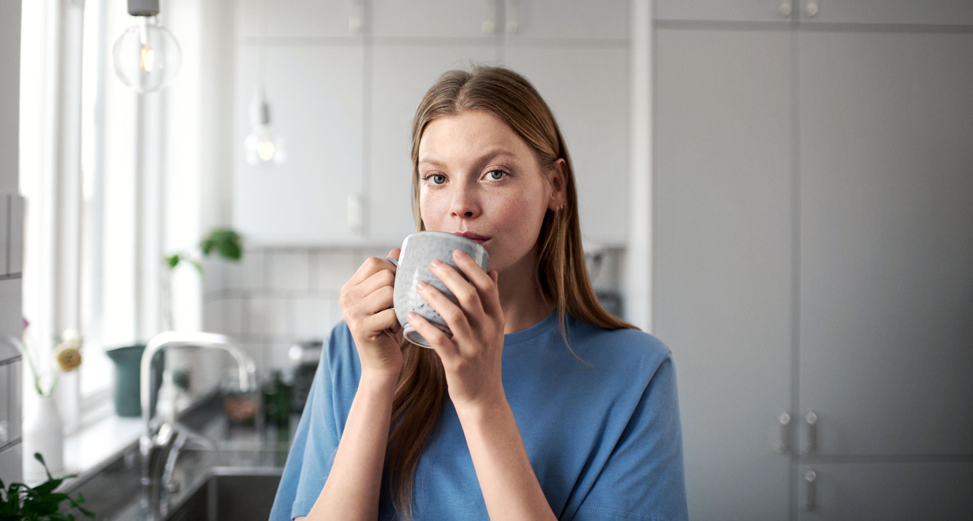 Vrouw in keuken met een grote beker koffie - Hoge jaarafrekening