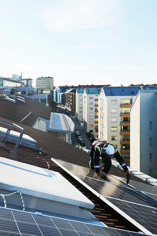 Zonnepanelen monteurs en zonnepanelen op een groot schuin dak in de stad - salderen