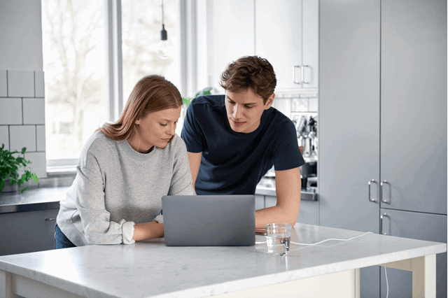 Man en vrouw achter laptop zoeken info over het prijsplafond voor energie