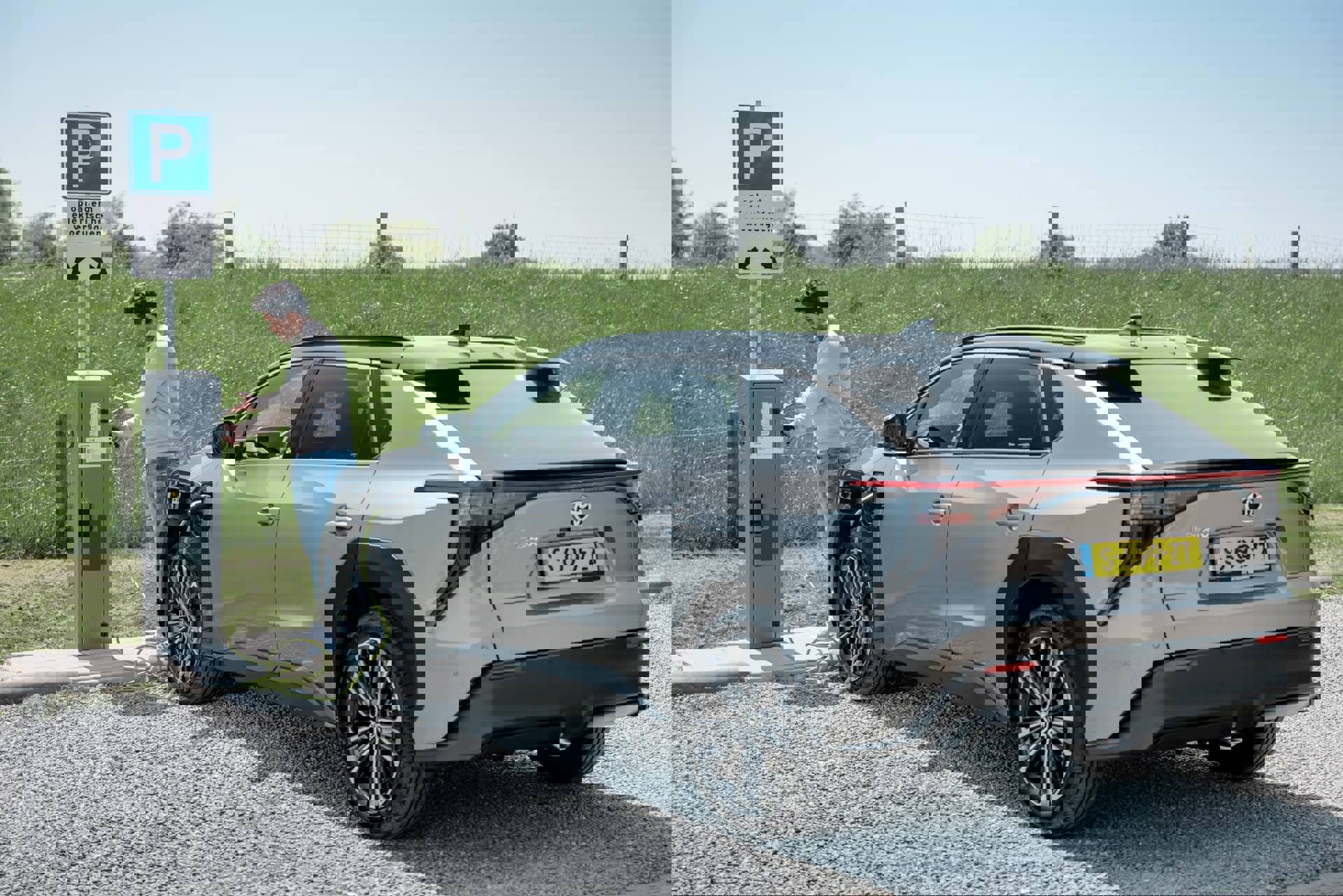 Man bij openbare laadpaal | Hoe lang duurt het opladen van een elektrische auto?