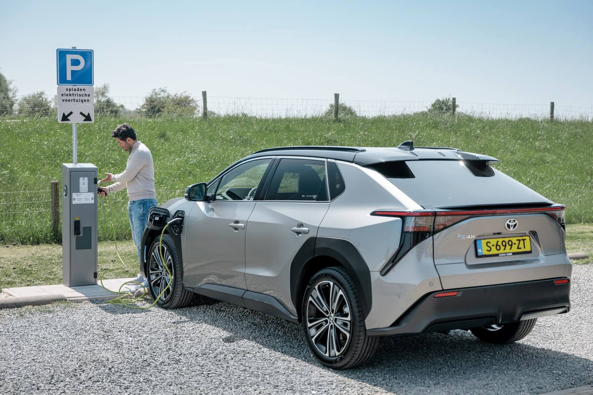 Man bij openbare laadpaal | Hoe lang duurt het opladen van een elektrische auto?