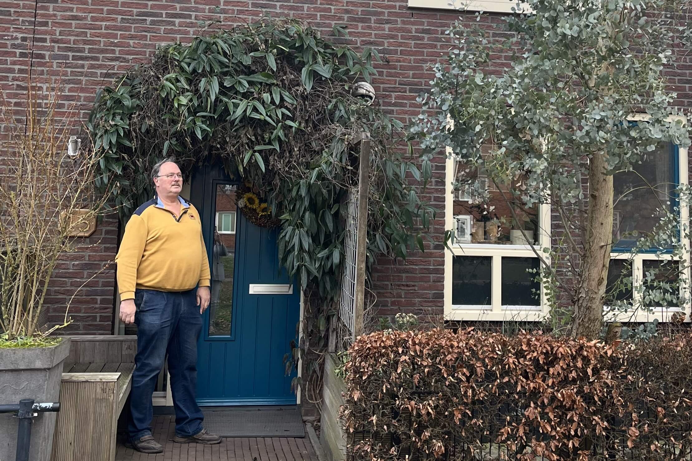 Bewoner staat voor zijn huis