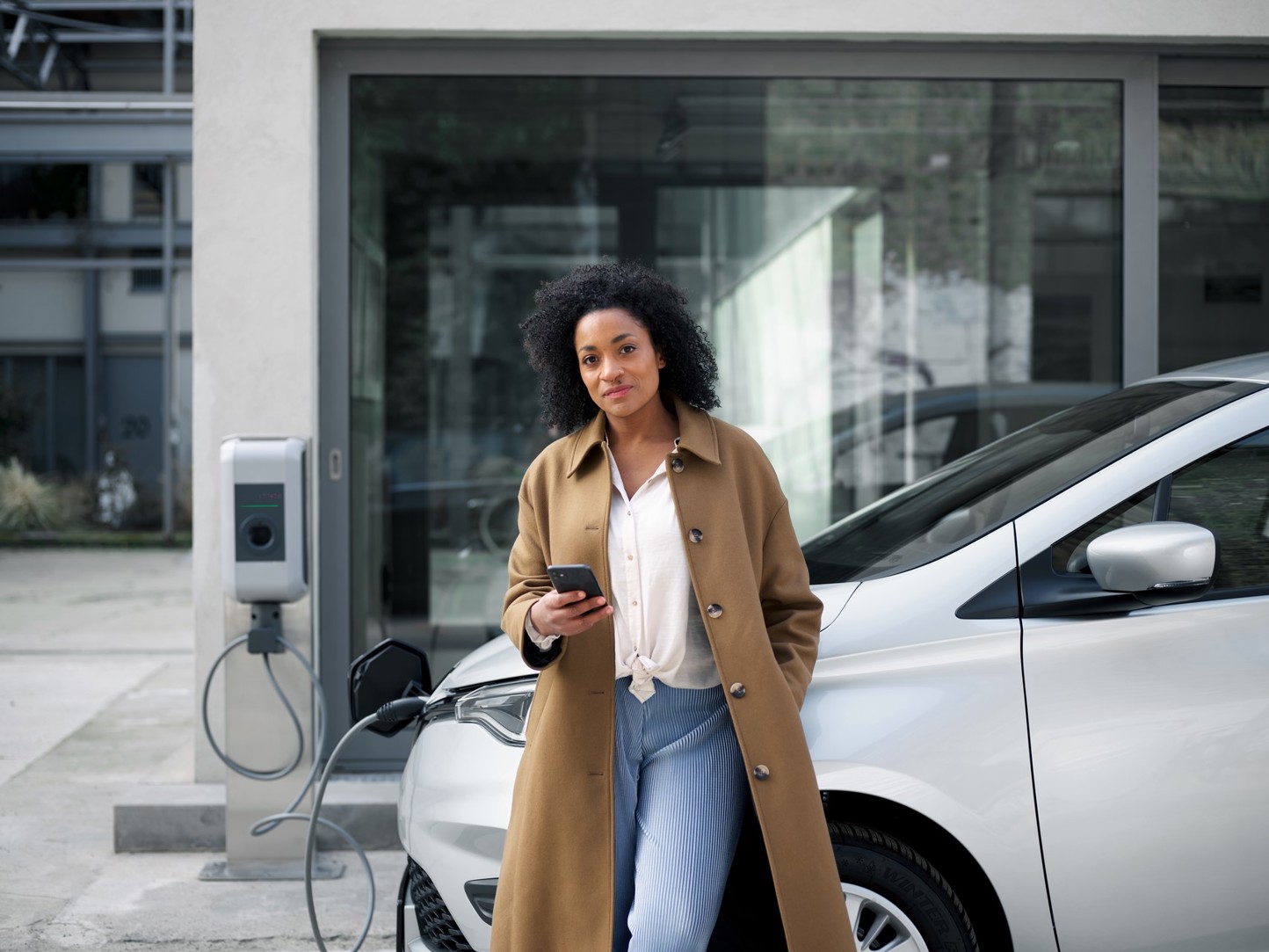 Vrouw met telefoon bij auto