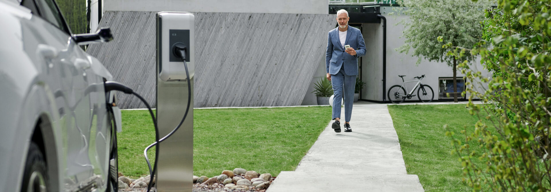 Man loopt van huis naar laadpaal