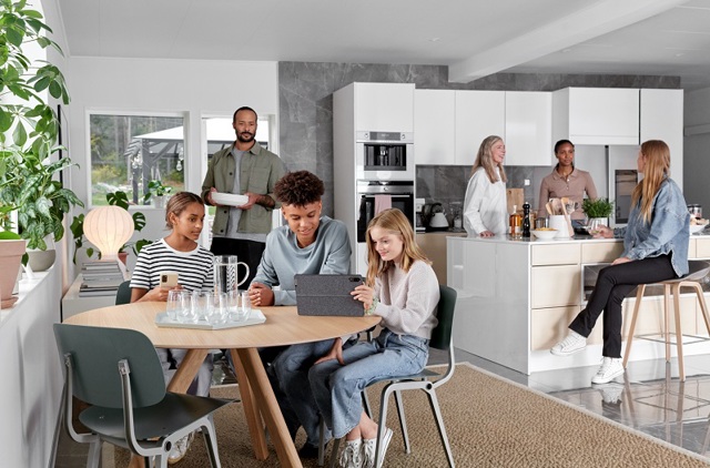 Familie en vrienden praten en lachen in de open keuken | Vattenfall over energieprijzen vergelijken