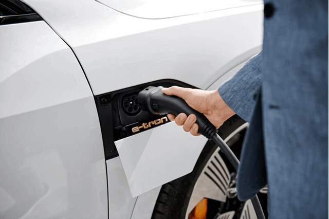Een witte elektrische auto wordt aangesloten om op te laden - Vattenfall over kosten laadpaal thuis