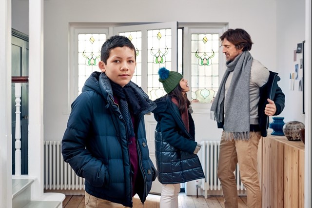 Vader, dochter en zoon in de gang met winterjassen aan | Verhuizen, wat regelen?