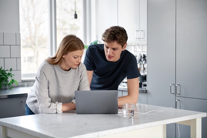 Jonge vrouw en man in de keuken met laptop hoeveel ze gaan betalen voor energie