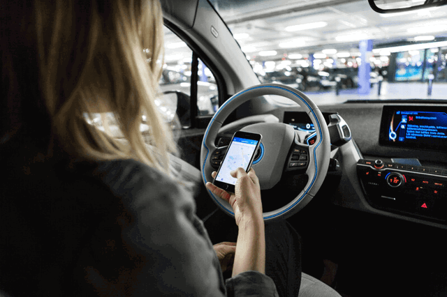 Vrouw met InCharge app in de auto in een parkeergarage