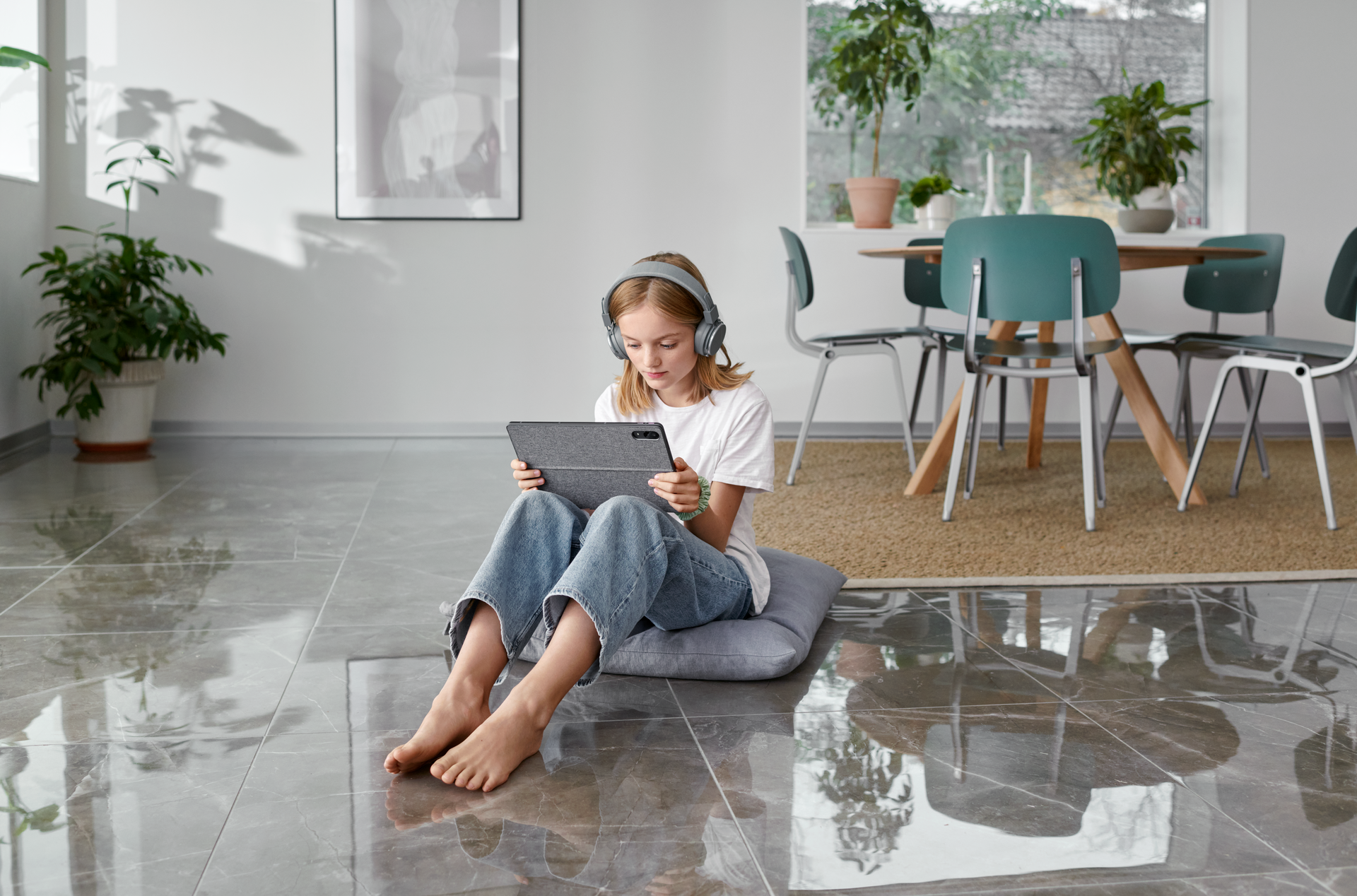 Meisje zit met blote voeten op de grond met haar laptop