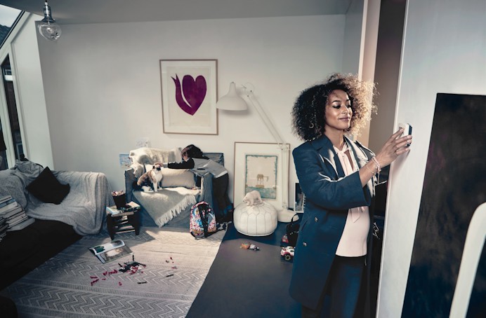 Vrouw zet verwarming lager