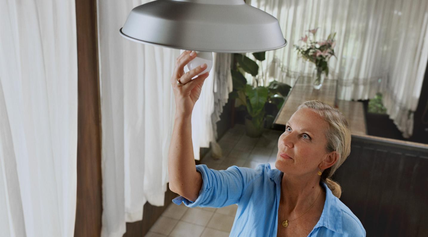 Mevrouw draait lamp in fitting