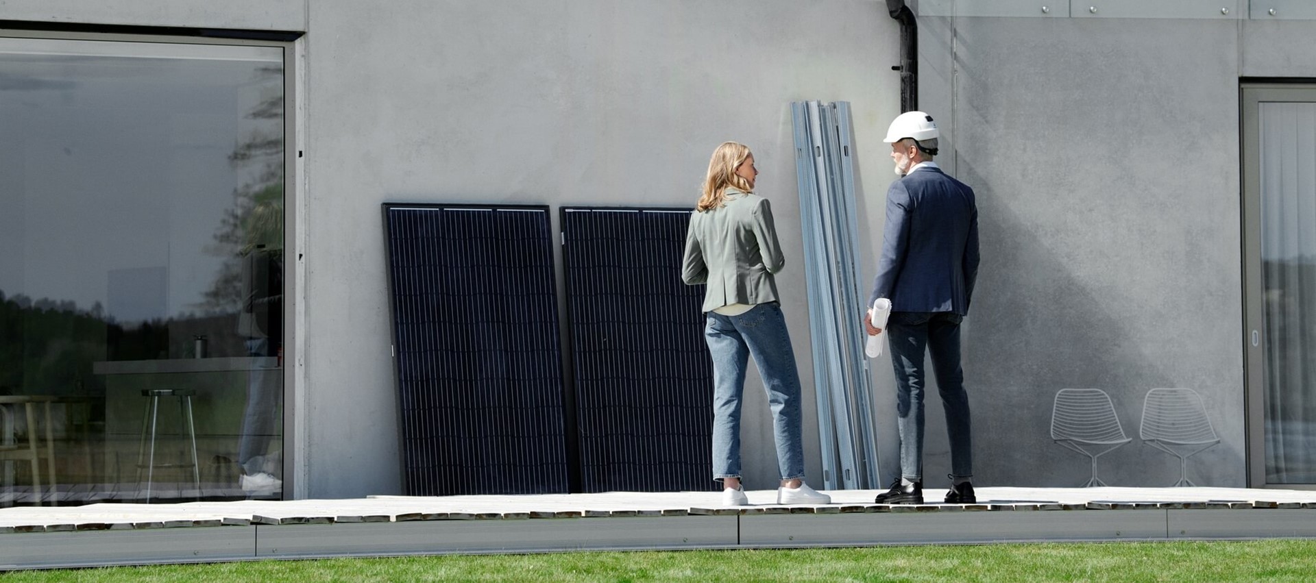 Vrouw praat met technische man over de zonnepanelen voor op dak