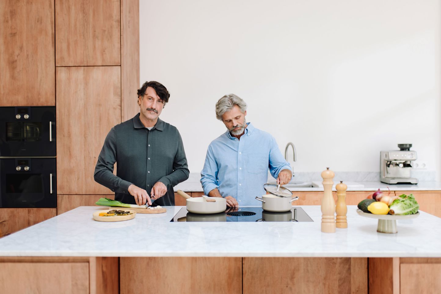 Stel in keuken die koken op inductiekookplaat Stel in keuken die koken op inductiekookplaat