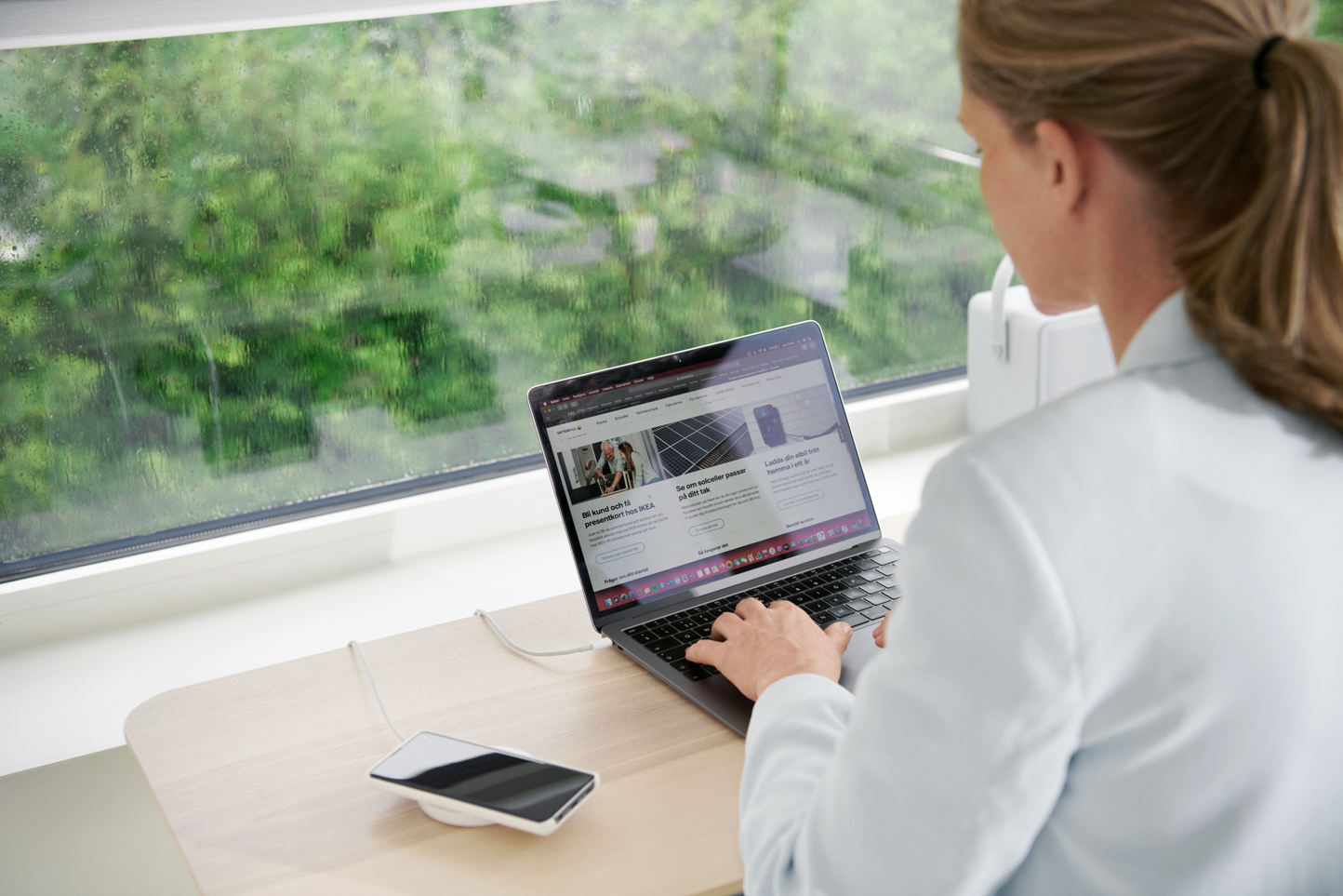 Vrouw zit aan tafel achter haar laptop te werken