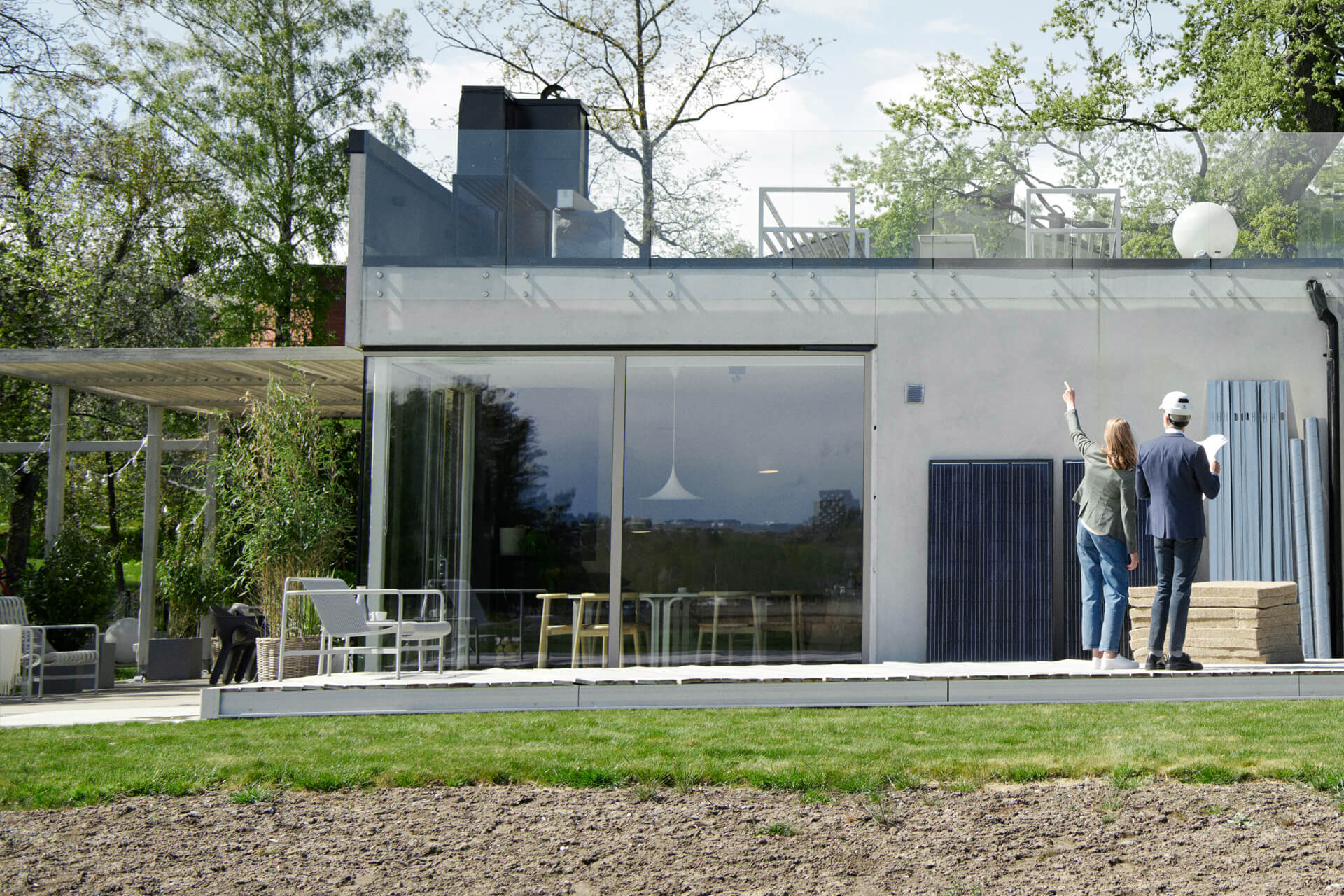 Man checkt de warmte in de huiskamer waar zijn vrouw aan tafel zit | Vattenfall over warmtepomp en zonnepanelen