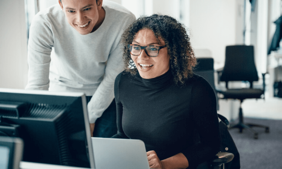 Man en vrouw zoeken op de computer naar handige hulpmiddelen om te verduurzamen op kantoor