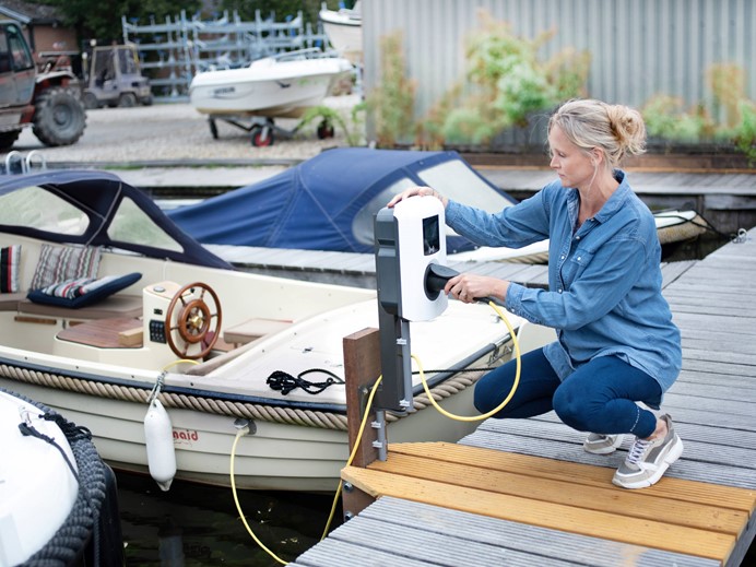 Rianne van Dusseldorp van Jachtwerf Van Dusseldorp steekt stekker in laadpaal van elektrische boot