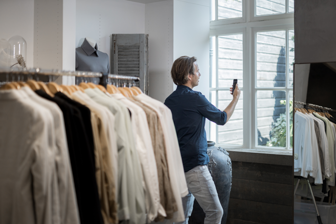 Meneer in winkel bekijkt energiebesparende tips op zijn mobiele telefoon