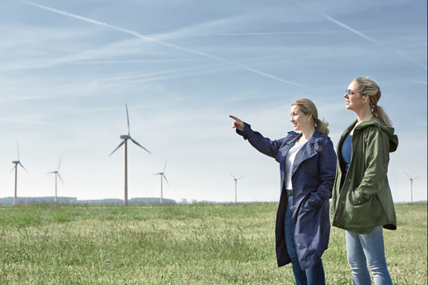 Twee vrouwen in weiland met windmolens