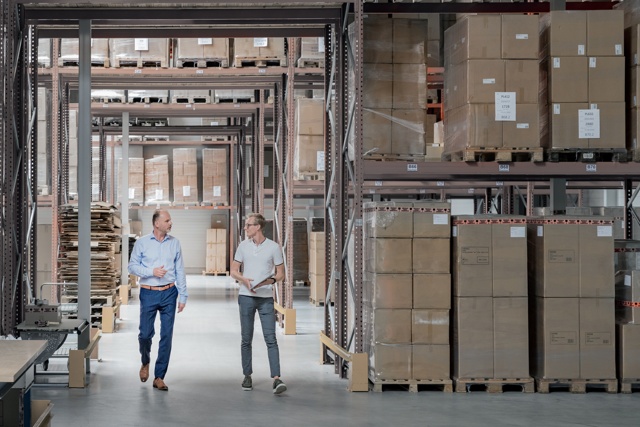 Twee mannen lopen door een magazijn
