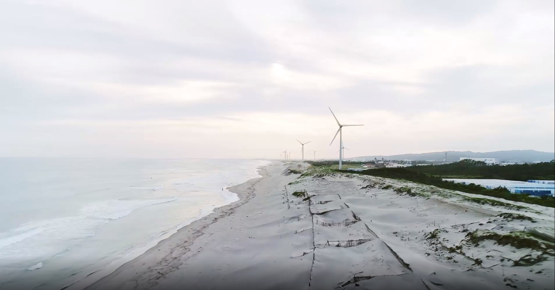 Video van draaiende windmolen op het land aan de zee