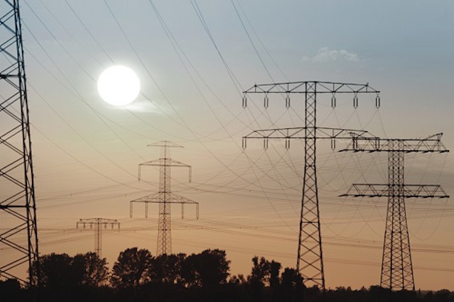 Grootzakelijke stroom en gas producten Elektriciteitsmasten tegen een ondergaande zon