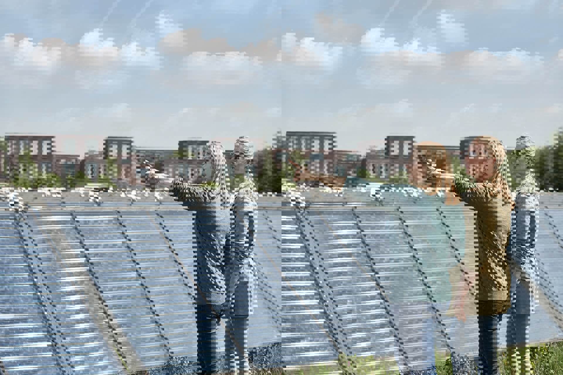 Duurzaamheid begint bij onszelf  | Vrouwen staan naast zonnepanelen in een zonnepark in een woonwijk.
