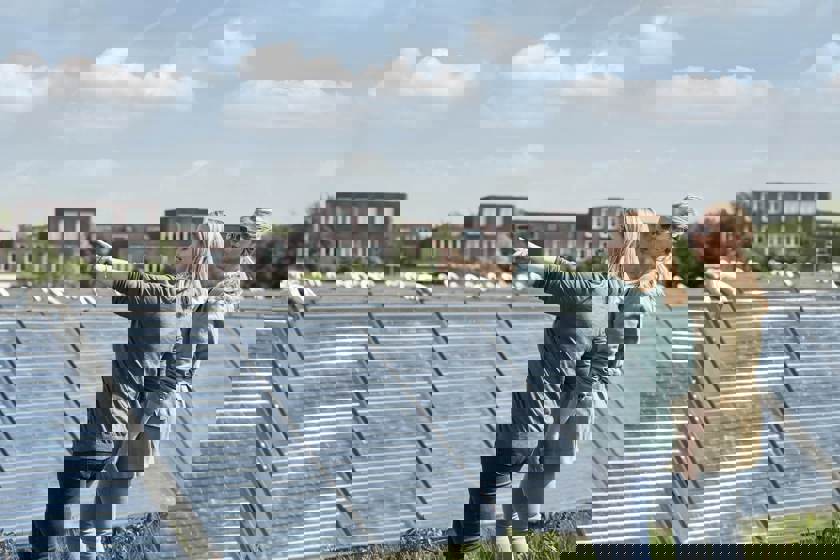 Twee vrouwen staan in een zonnepanelenpark