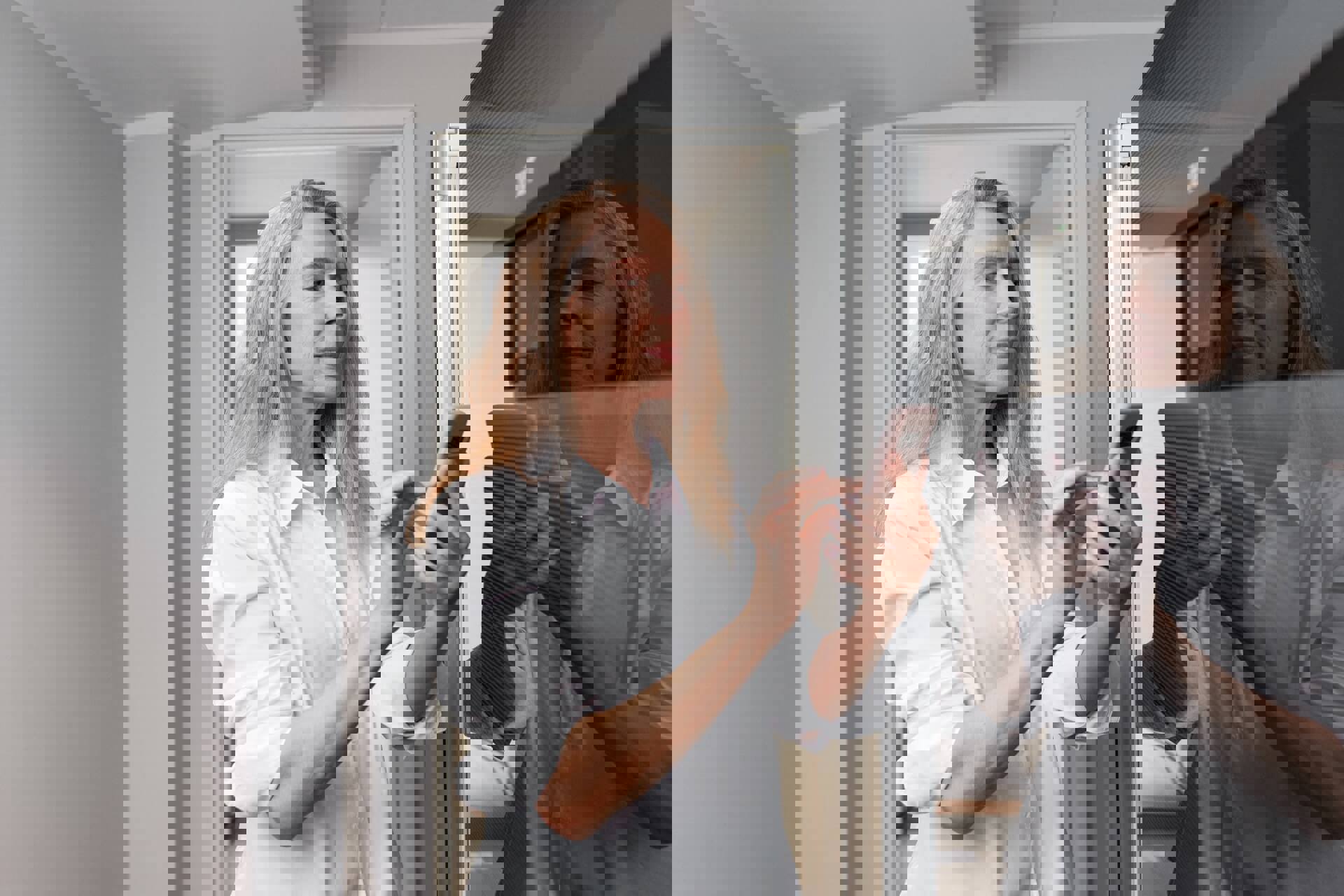 Vrouw checkt de verwarming in haar huis met behulp van haar smartphone. In verband met energiebelasting en overheidsheffingen