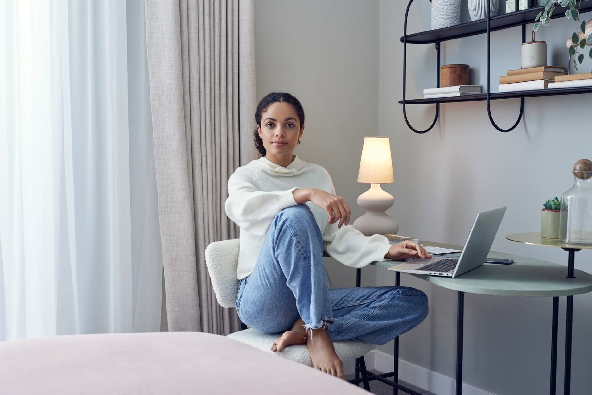 Vrouw zit met haar laptop aan een bureautje in de slaapkamer | Informatie van Vattenfall over energiekosten