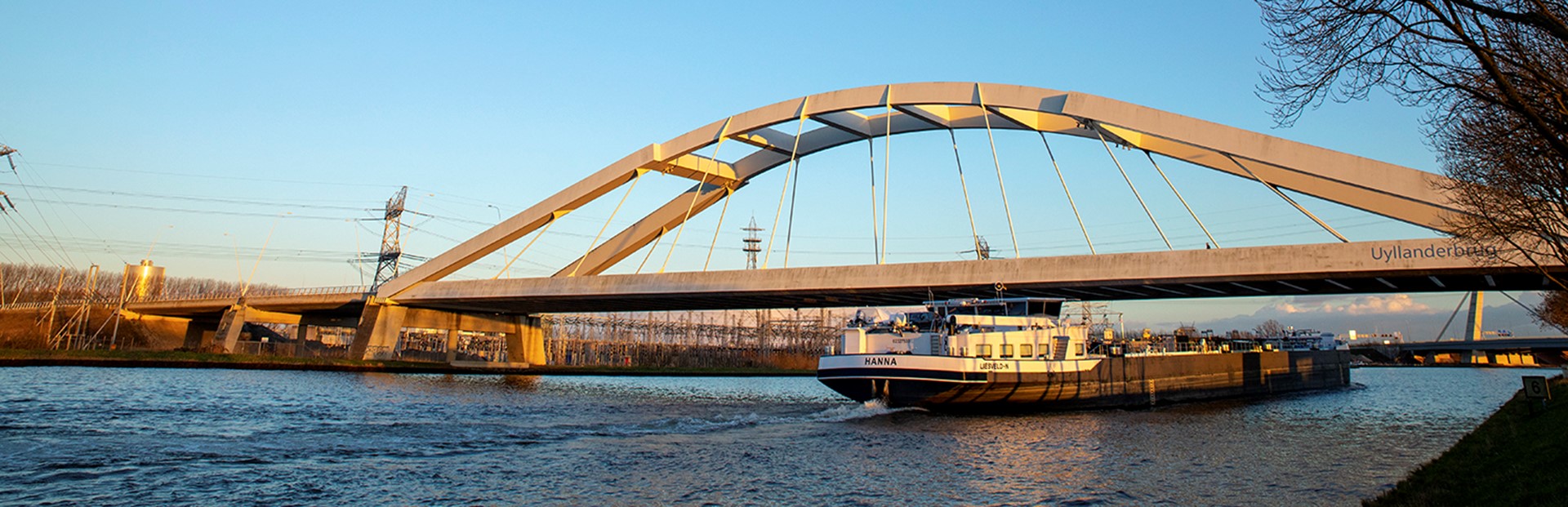 De biowarmte-installatie in Diemen. Boot op de rivier onder de brug door | Vattenfall over biomassa