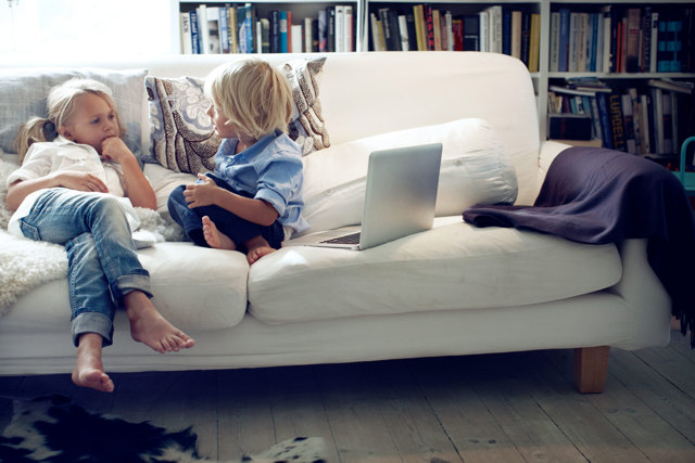 2 kinderen spelen op de bank met een laptop | Vattenfall energie