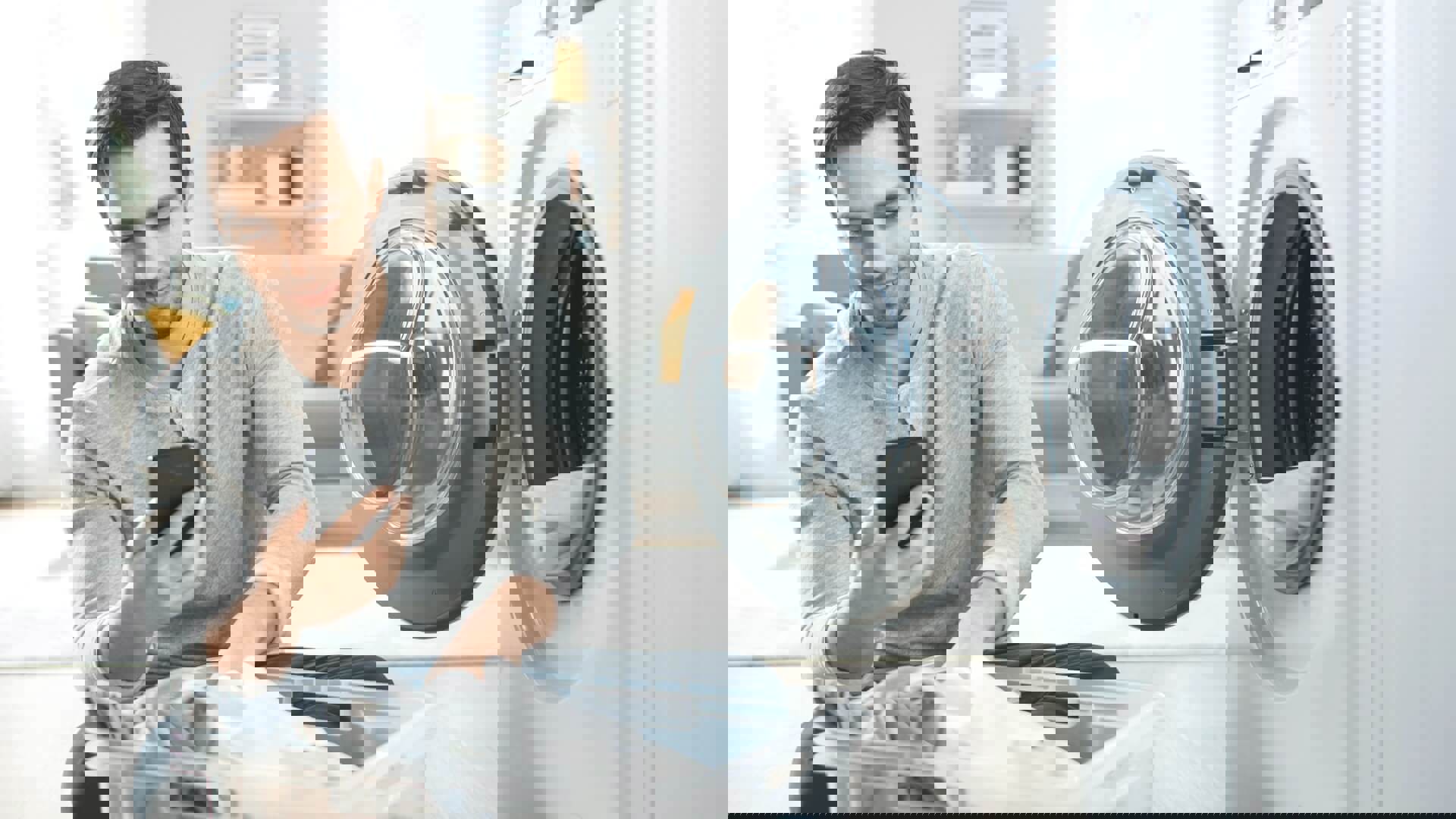 Man kijkt op zijn mobiel terwijl hij de was in de wasmachine doet | Goedkoopste gas elektra