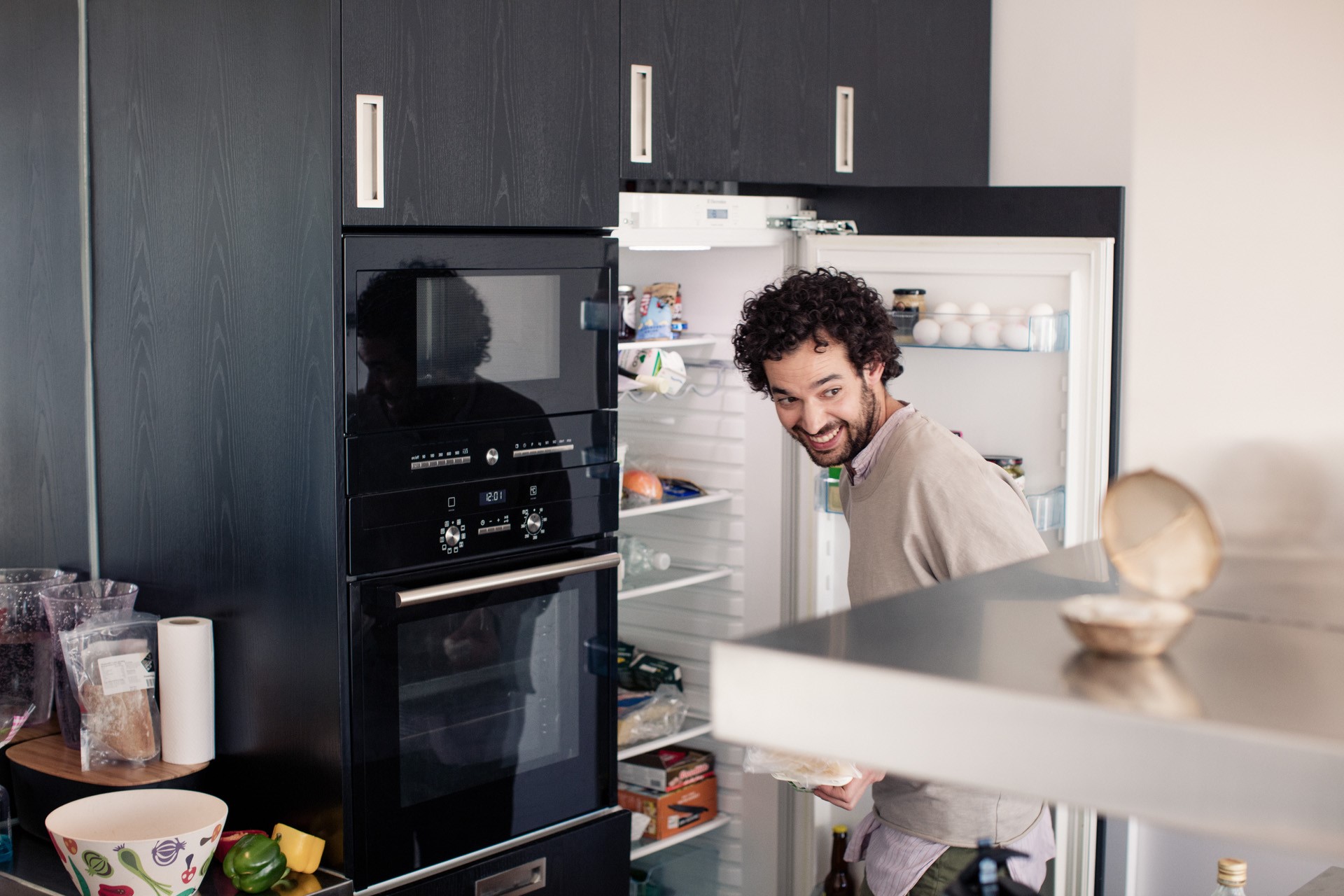 Enthousiaste man kijkt blij in zijn koelkast | Vattenfall energielabel koelkast