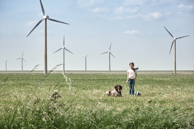 Meisje met hond in weiland met windmolens | Vattenfall over energie