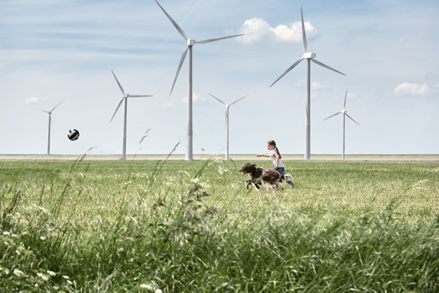 Meisje rent met hond in windmolenpark | Vattenfall over wat is groene stroom