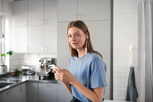 Jonge vrouw met smartphone in de keuken | Vattenfall Energie app