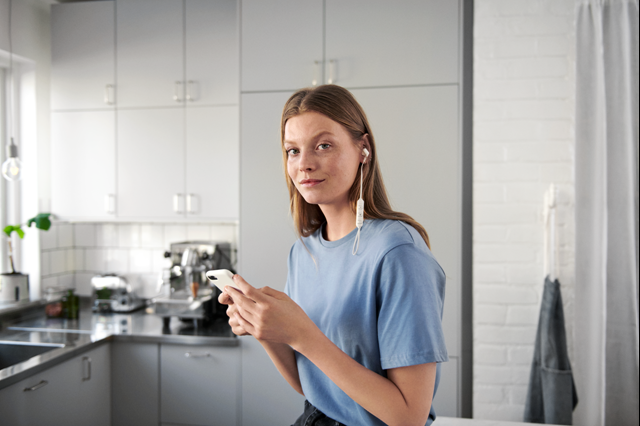 Jonge vrouw met smartphone in de keuken | Vattenfall Ondernemersdesk