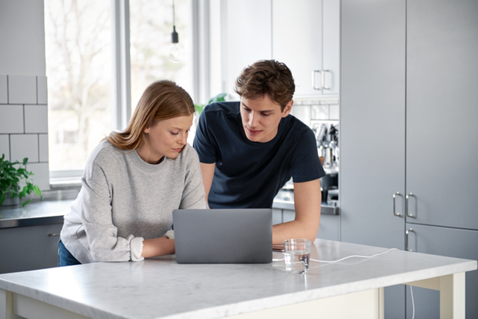 Jong stel in keuken achter de laptop met energie nieuws