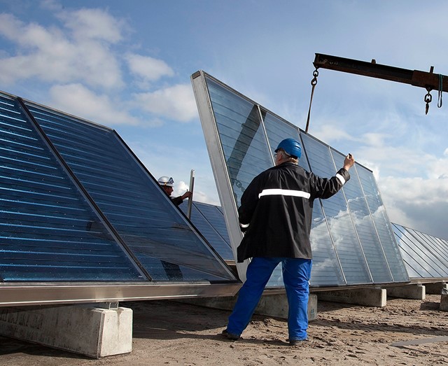 Twee mannen plaatsen zonnepanelen voor een bedrijf