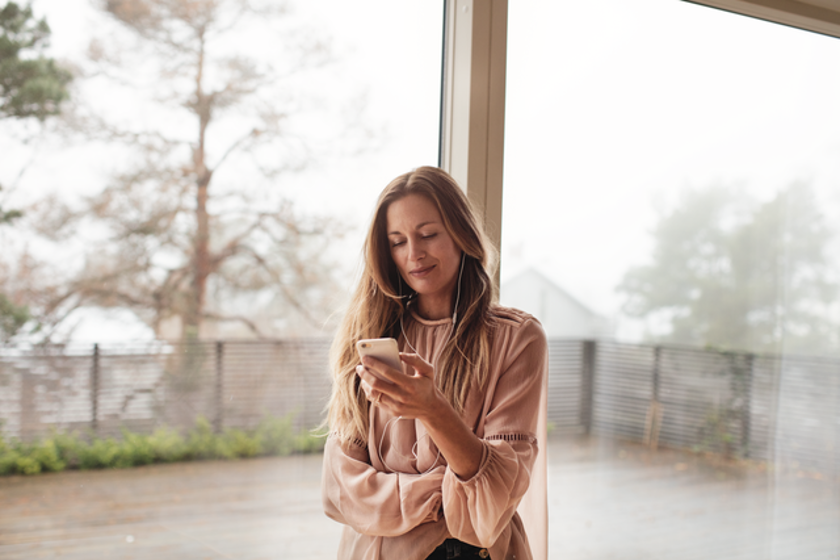 Vrouw kijkt thuis op haar mobiele telefoon