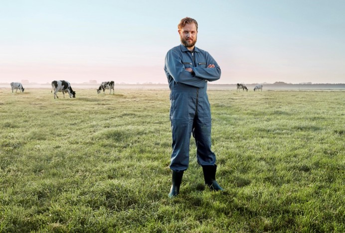 Boer in weiland met koeien