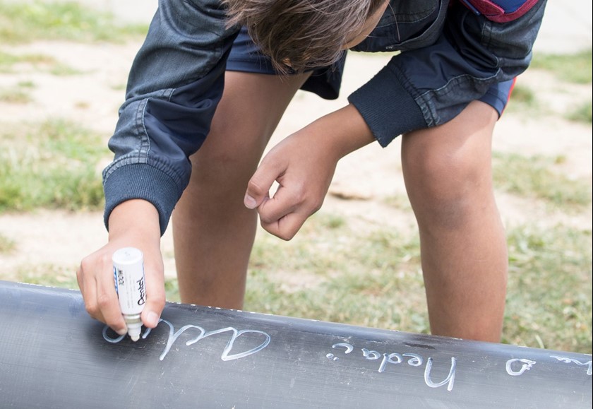 Kind schrijft met krijt op een muurtje l Vattenfall energie