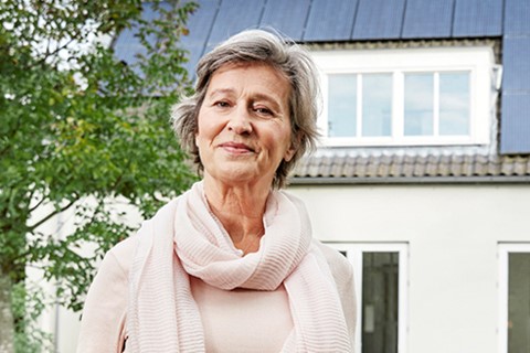 Vrouw voor huis met zonnepanelen