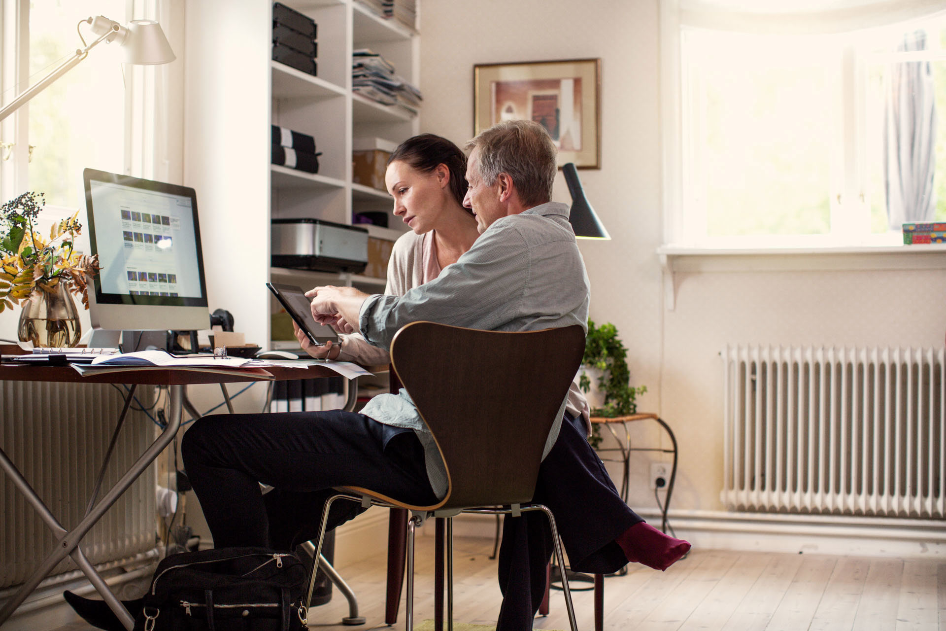 Echtpaar thuis aan een bureau kijkend op laptop l Vattenfall energie