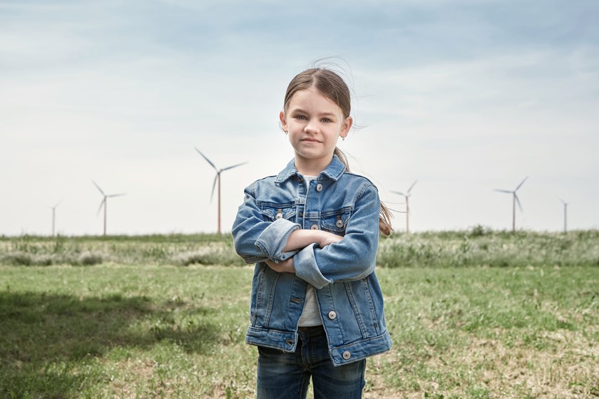 Meisje poseert in weiland met windmolens l Vattenfall energie
